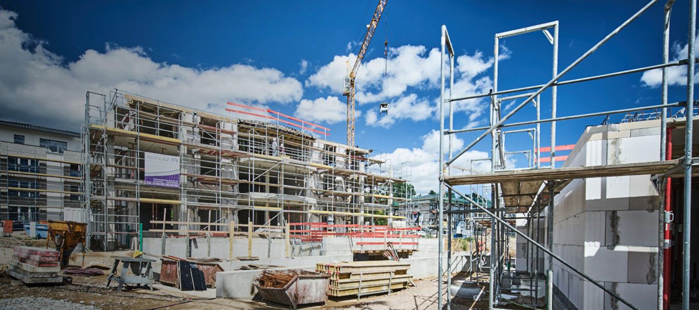 Baustelle mit Baugerüsten und Baukränen